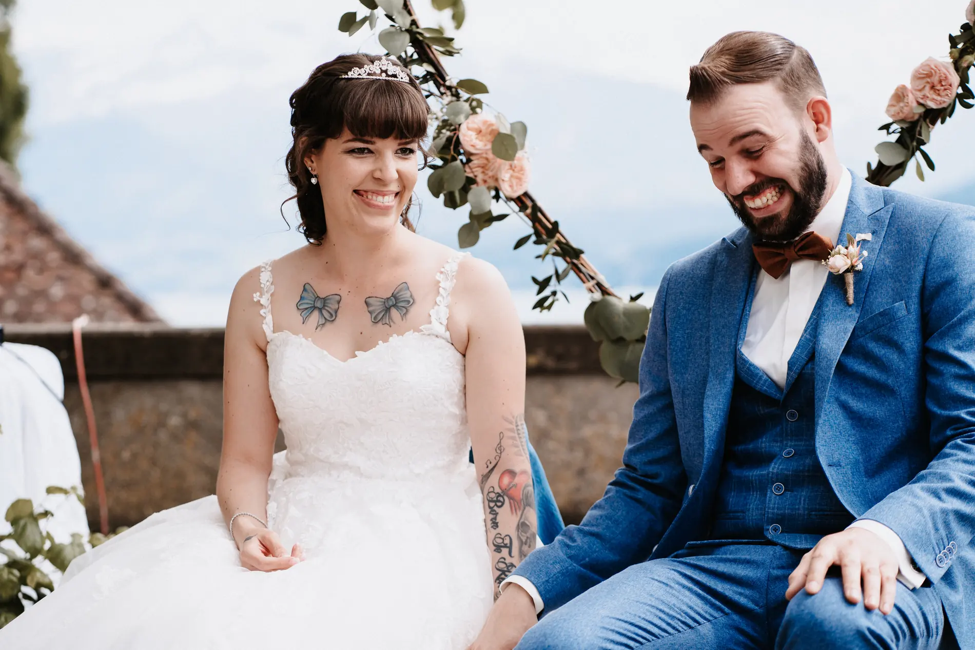 Laughing couple under a floral arch