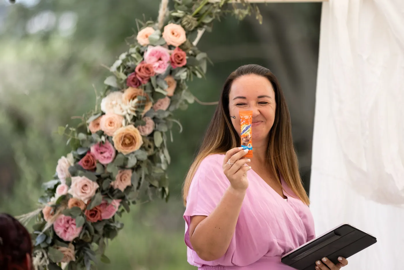 Manuela bei einer freien Trauung vor einem Blumenbogen